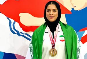 بانوی قمی در آوردگاه جهانی بر سکوی سوم کشتی با کمربند ایستاد