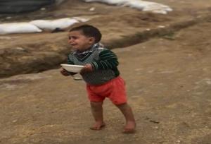 صحنه دردناک؛ کودکی زیر باران با ظرف خالی و چشمان گریان+فیلم