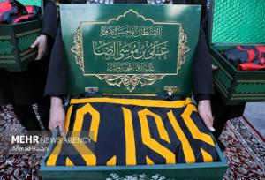 حضور خادمان امام رضا(ع) با پرچم متبرک حرم رضوی در نمایشگاه کتاب