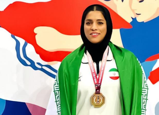 بانوی قمی در آوردگاه جهانی بر سکوی سوم کشتی با کمربند ایستاد