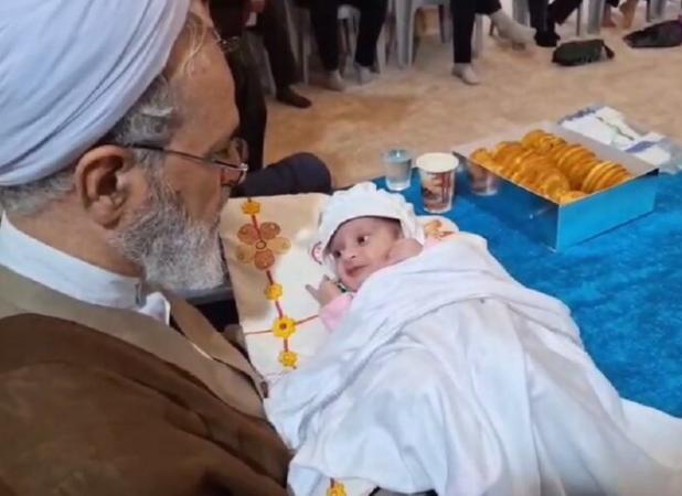 اذان آیت‌الله اعرافی در گوش نوزاد پس از نماز عید قربان