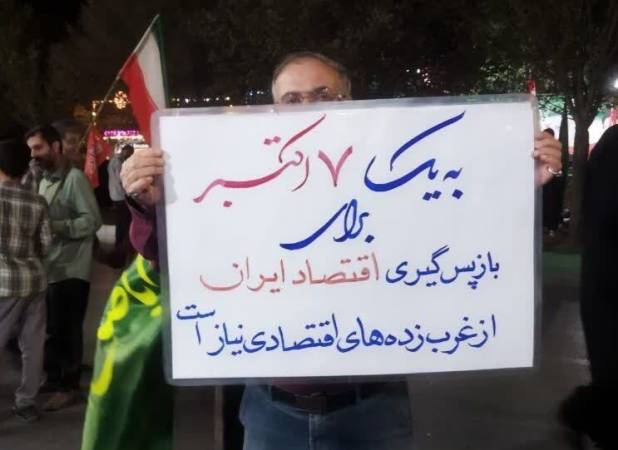 بنر عجیب در تجمعات شبانه: به یک ۷ اکتبر برای بازپس‌گیری اقتصاد ایران از غرب‌زده‌های اقتصادی نیاز است! + عکس